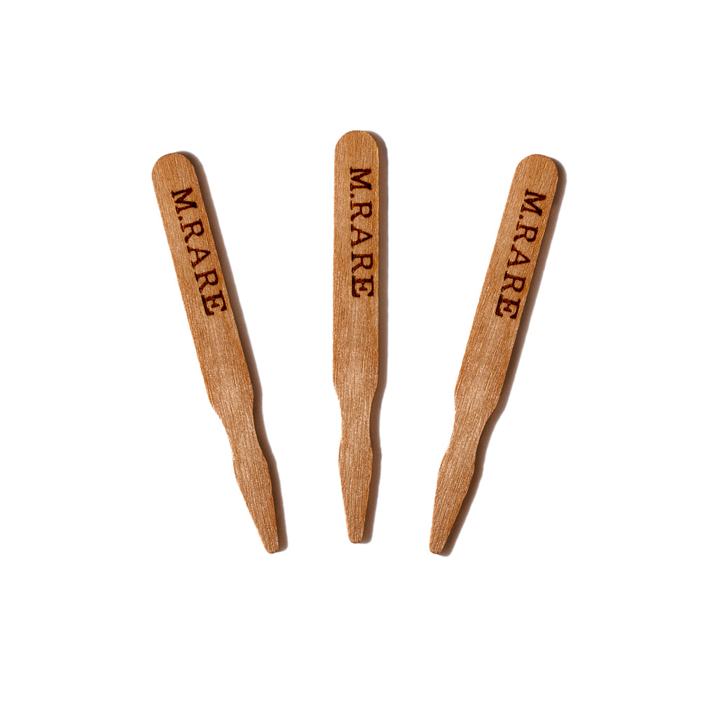Three wooden steak markers with the word "M. RARE" engraved on each.