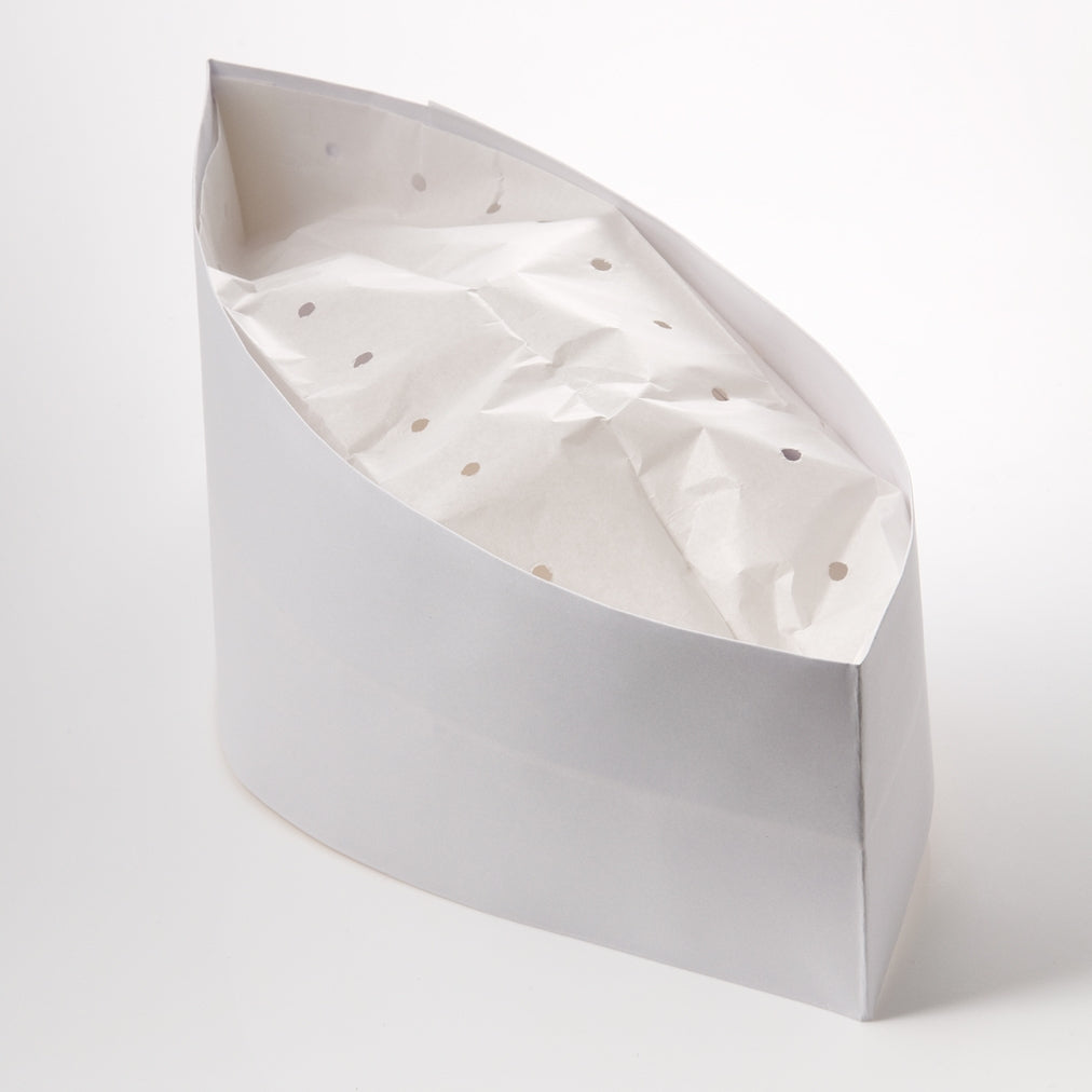 White paper boat-shaped container lined with crumpled polka-dot tissue paper on a plain white background, creating a clean, minimalist tone.
