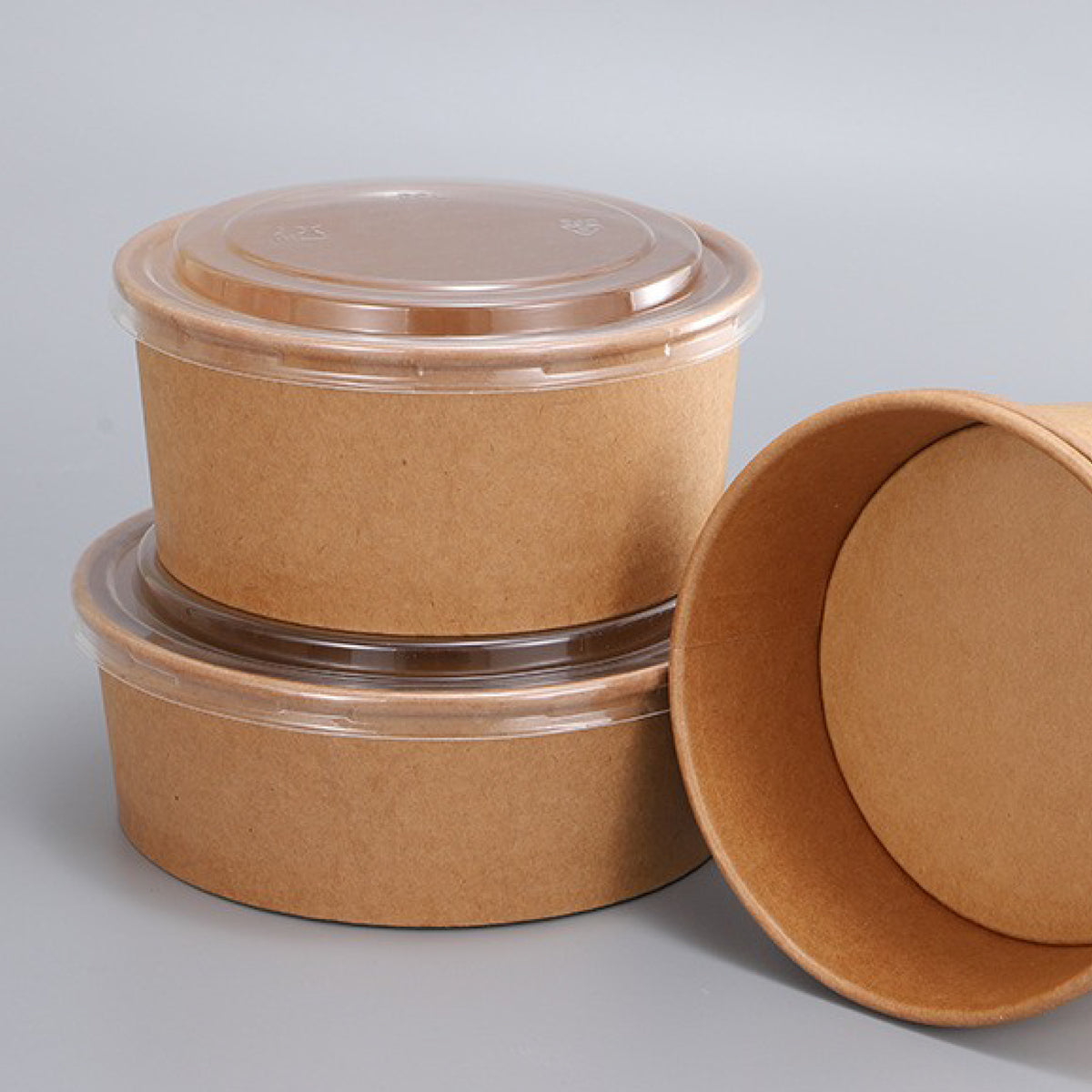 Three round, kraft paper food containers with clear plastic lids.