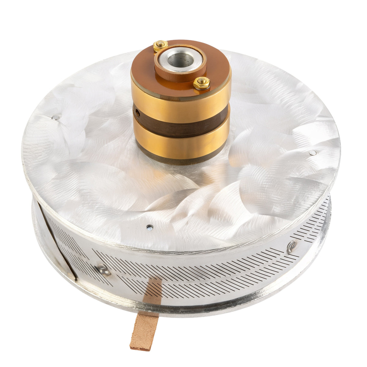 A round object with a metallic base, featuring a central cylindrical structure surrounded by concentric rings, all mounted on a flat surface.