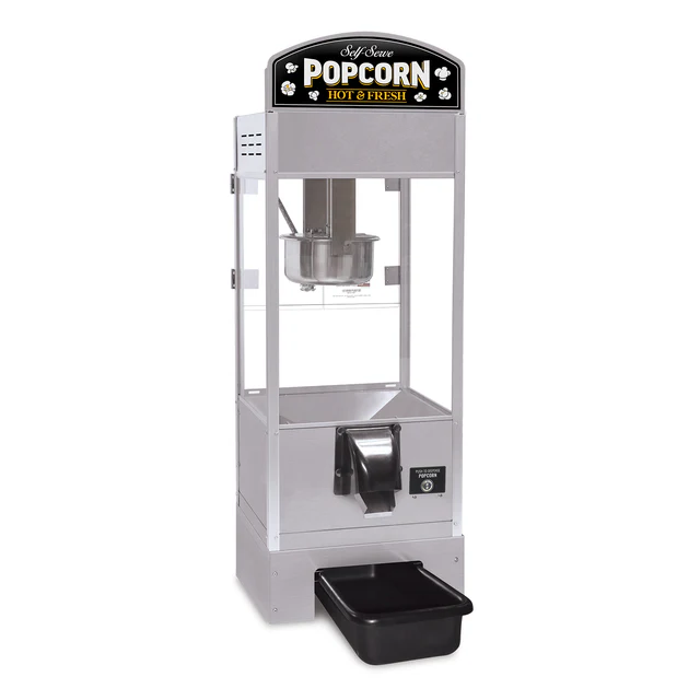 Silver popcorn machine with a transparent case, displaying "Self Serve Popcorn Hot & Fresh" on top. Features a chute and catch tray below, offering a retro feel.