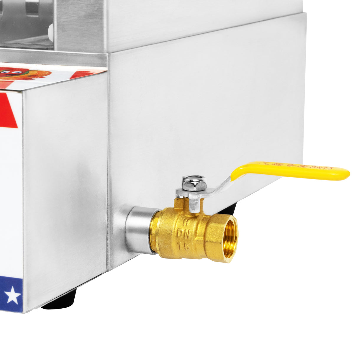 A close-up of a brass ball valve with a yellow lever handle attached to a stainless steel appliance.