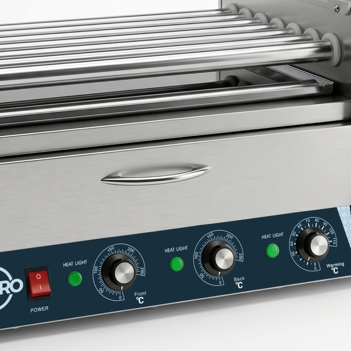 Close-up of a stainless steel roller grill with temperature dials and a red power switch. Green lights indicate active heating, suggesting it is powered on.