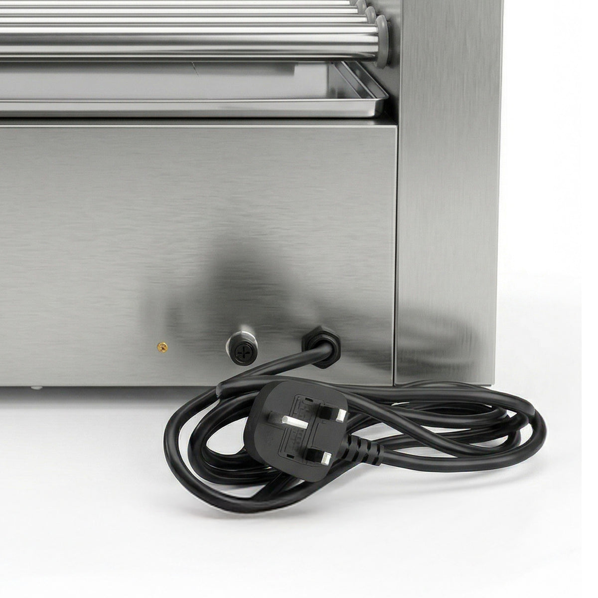Close-up of a stainless steel appliance with a coiled black power cord and a UK three-prong plug on a white background.