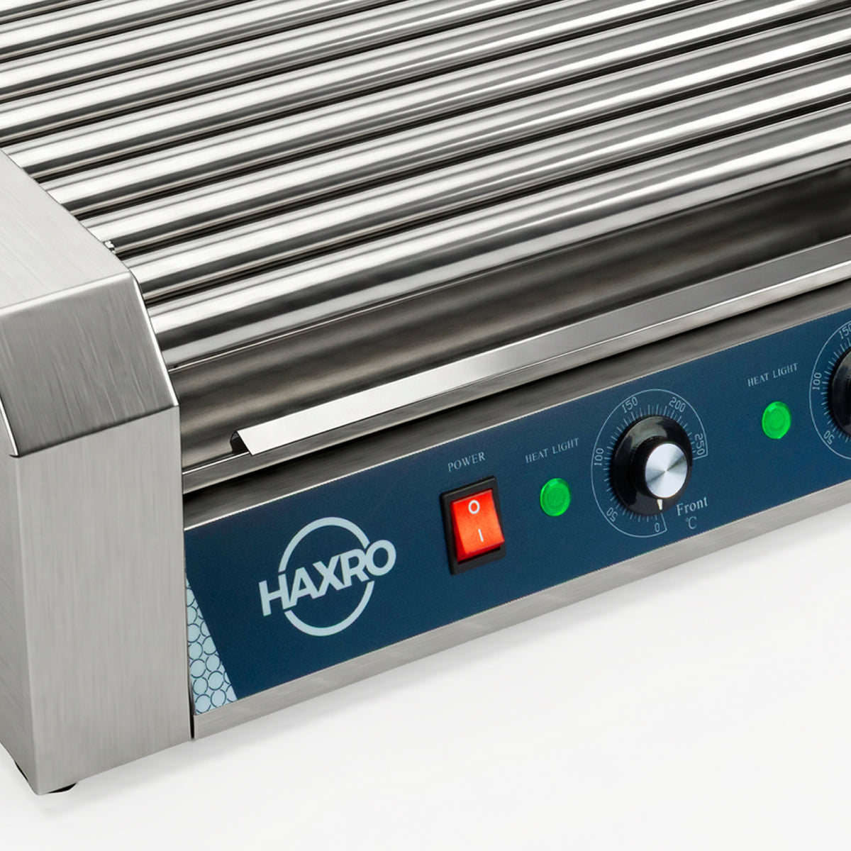 Close-up of a sleek stainless steel hot dog roller grill with control dials, a red power switch, and green indicator lights. The brand logo is visible.