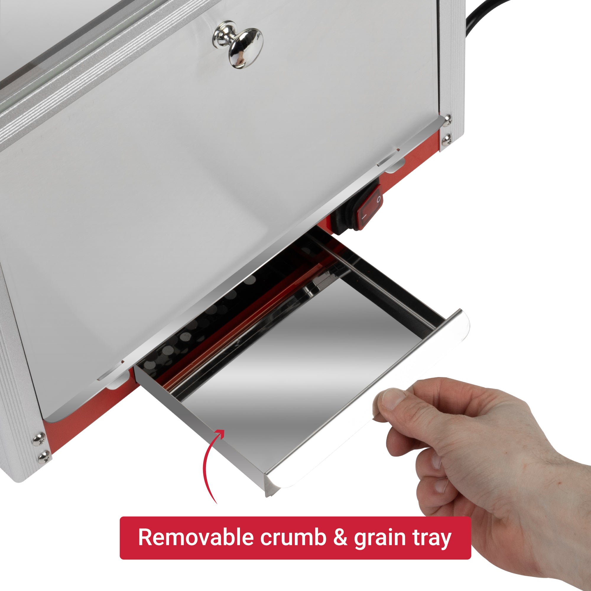 A hand pulls a shiny, removable crumb and grain tray from a sleek silver appliance. The tone is practical and clean, emphasizing easy maintenance.
