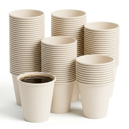 A stack of beige paper cups with one filled with black coffee in the foreground. The arrangement conveys abundance and simplicity.
