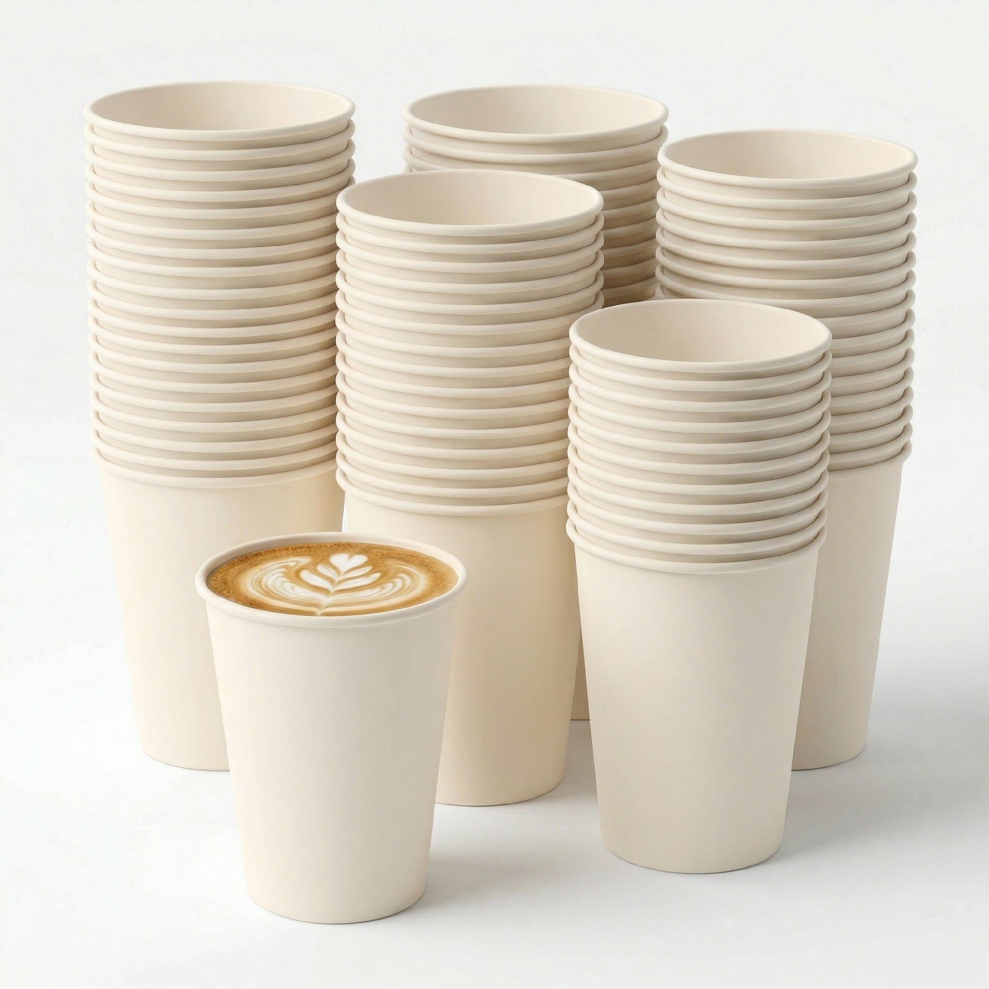 A single coffee cup with latte art sits in front of several stacks of plain, beige disposable cups. The scene conveys simplicity and minimalism.