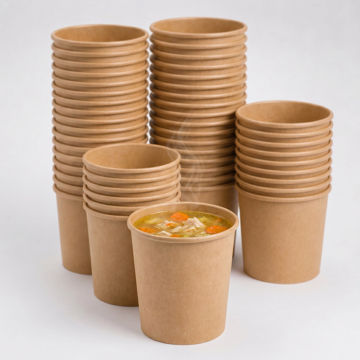 Stacks of Kraft Brown paper cups with one containing soup on a white background