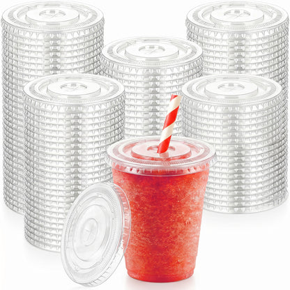 Plastic lids stacked in columns form the background. In the foreground, a red icy drink in a clear cup with a red-and-white striped straw.
