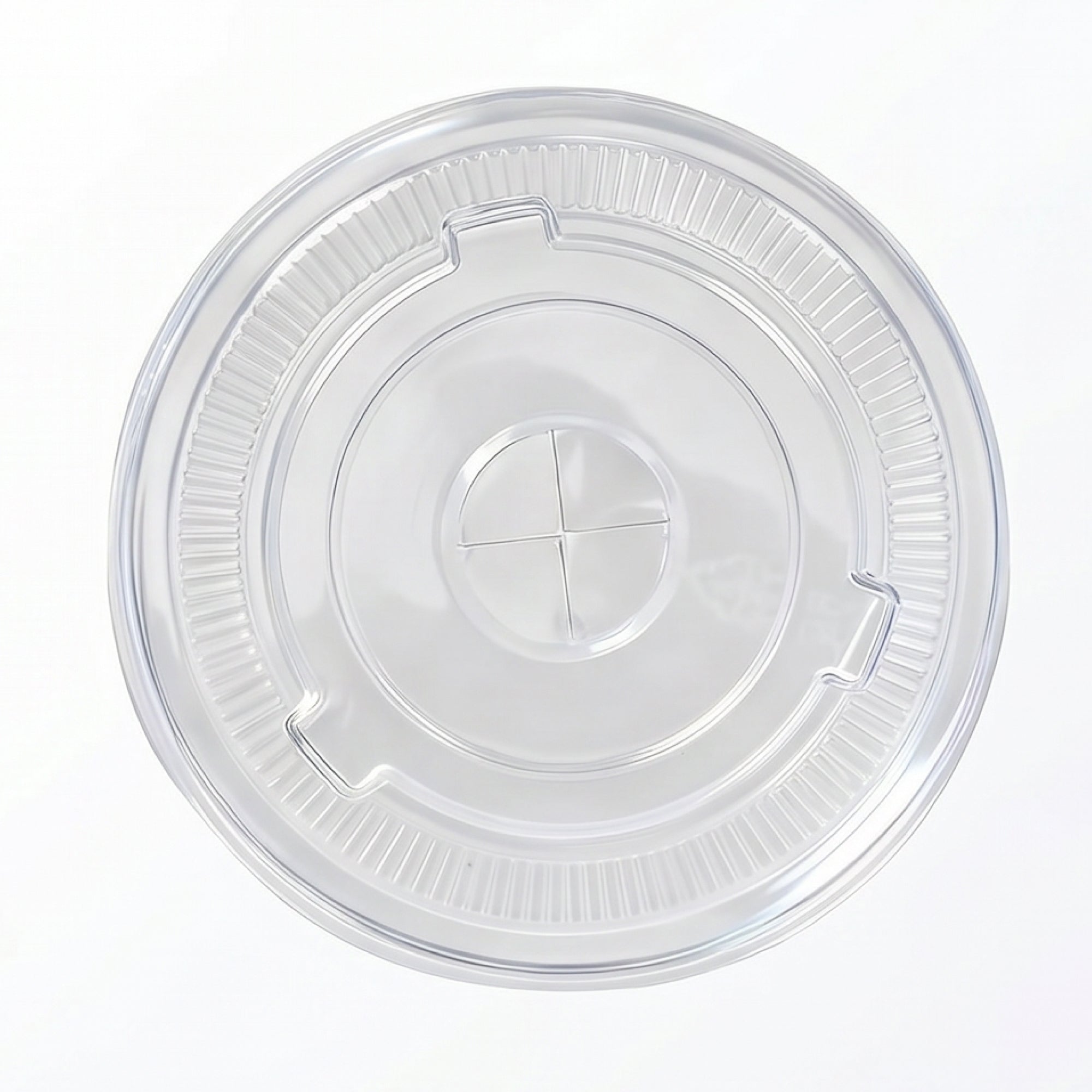 Clear, circular plastic lid with ribbed edges and a central cross-shaped indentation. The lid is set against a white background, conveying a sense of simplicity and cleanliness.