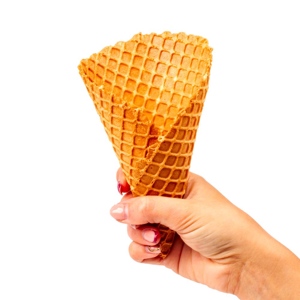 A hand holding an empty ice cream cone.