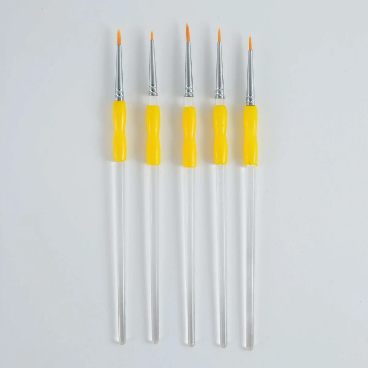Five fine detail paint brushes with bright yellow handles and silver ferrules, arranged vertically on a plain light gray background.