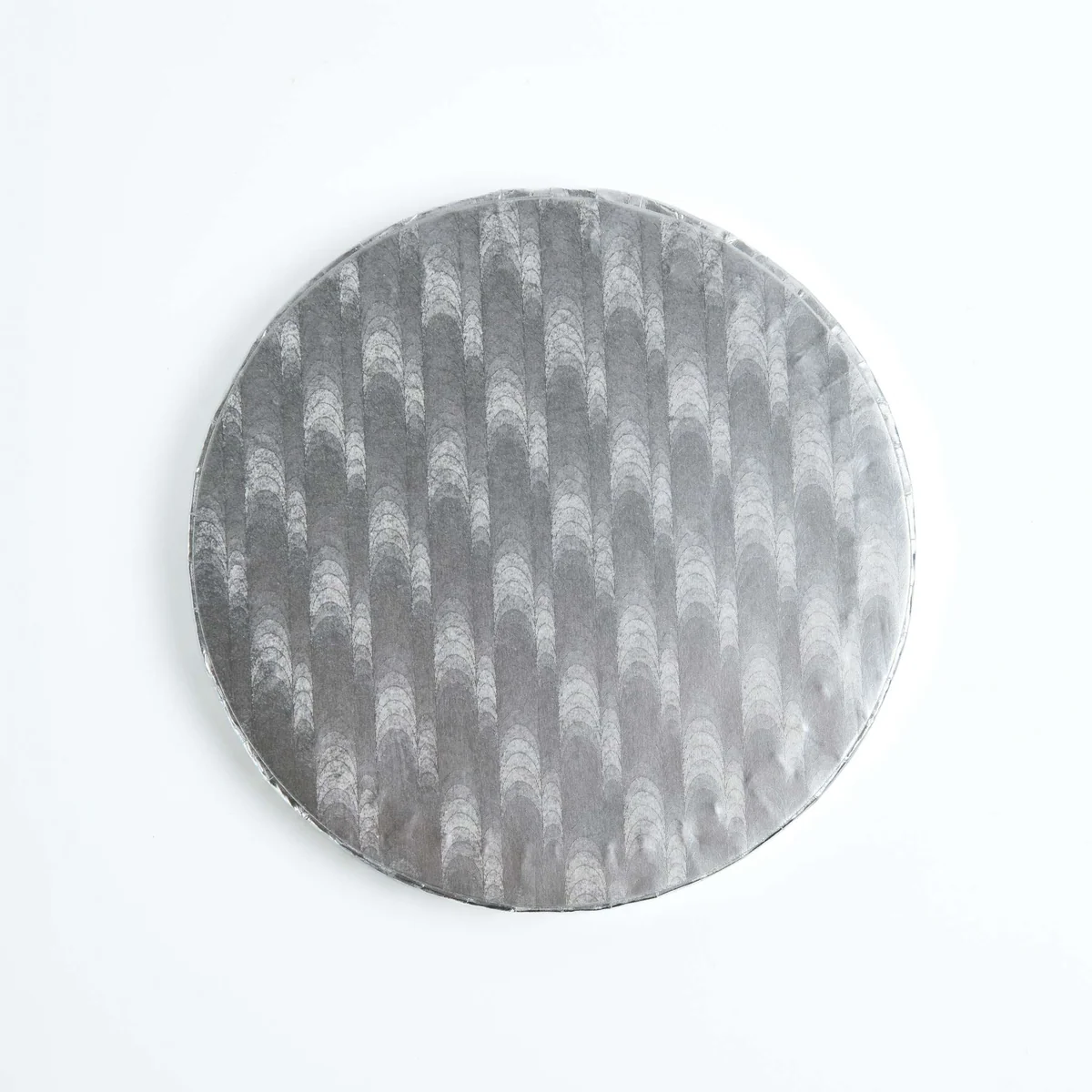 A round gray cake or pizza cutter with a textured, ribbed pattern, shown against a plain white background.
