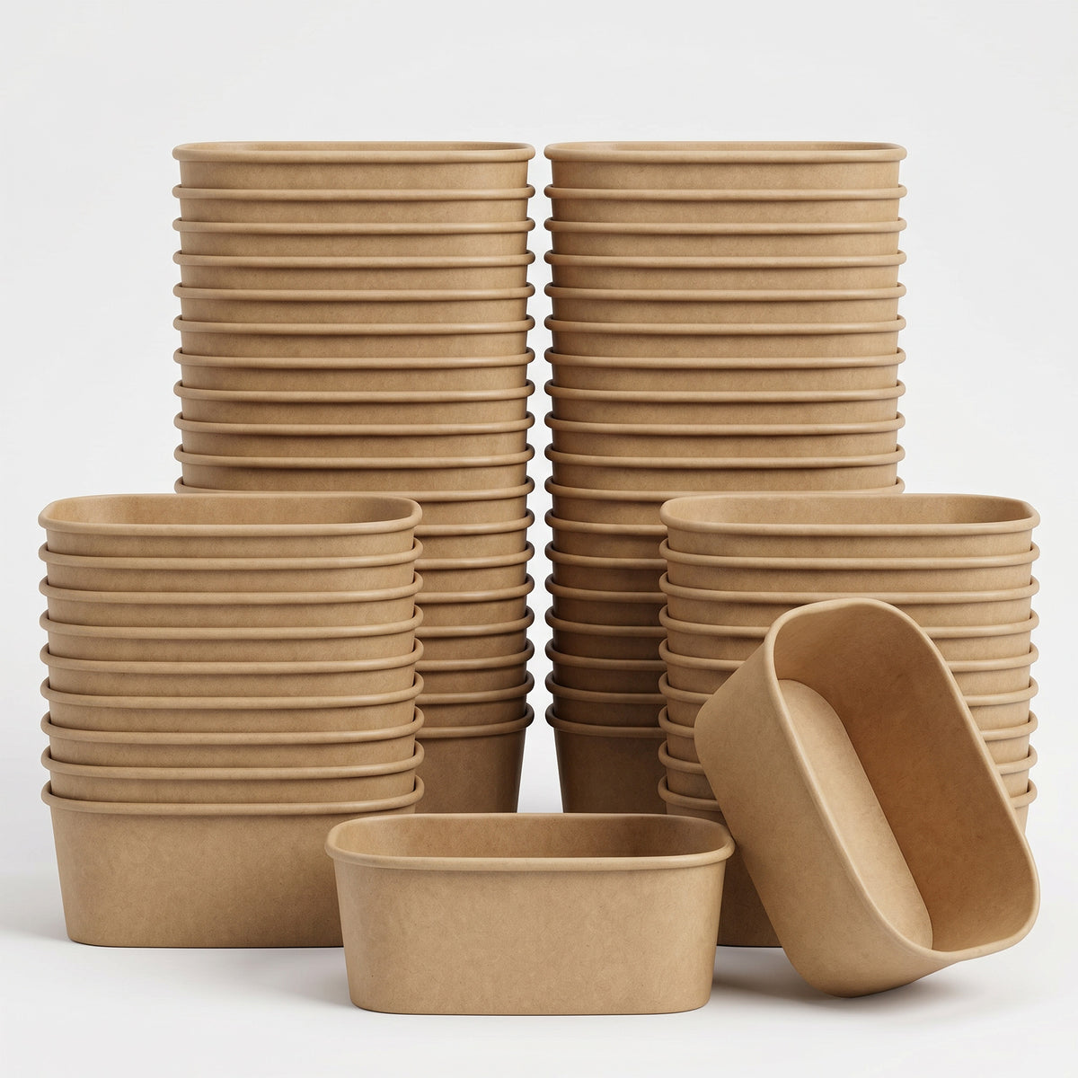 Stacks of brown, oval-shaped biodegradable bowls arranged neatly. One bowl is tilted, showcasing its depth. The setting is minimalist and neutral.