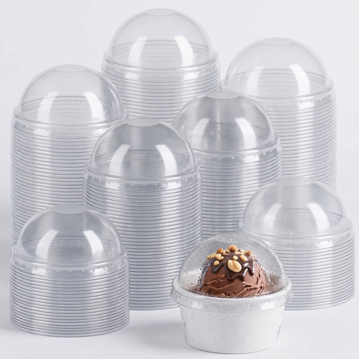 Stacks of empty clear plastic dessert cups with dome lids are arranged in the background. In front, one cup is filled with chocolate dessert.