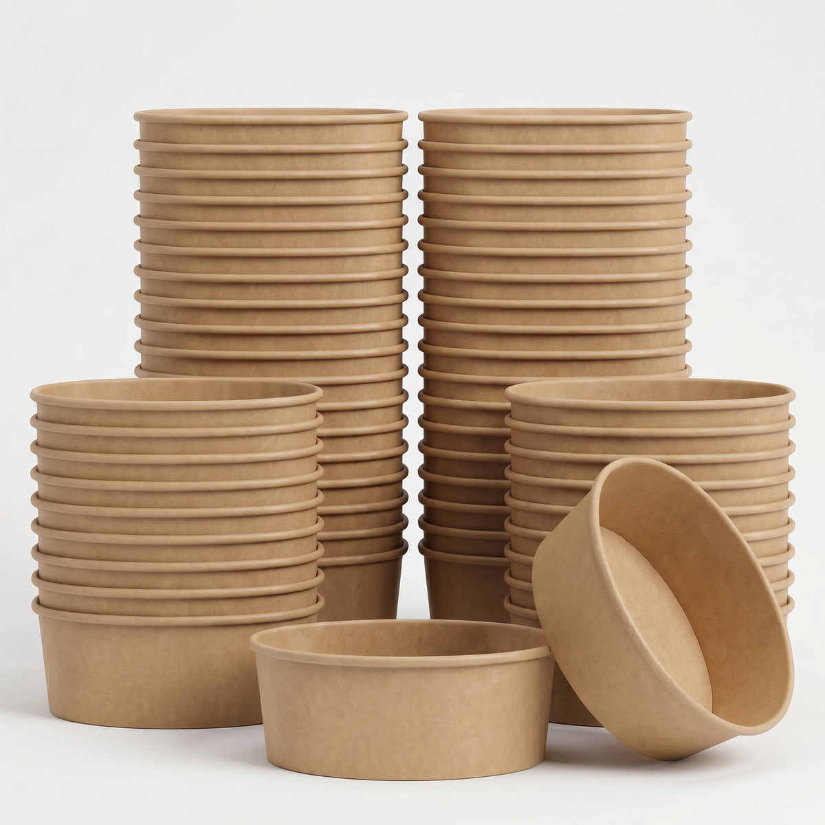 Stacks of brown, eco-friendly, compostable bowls are arranged against a plain background. One bowl is tipped, showing its smooth interior.