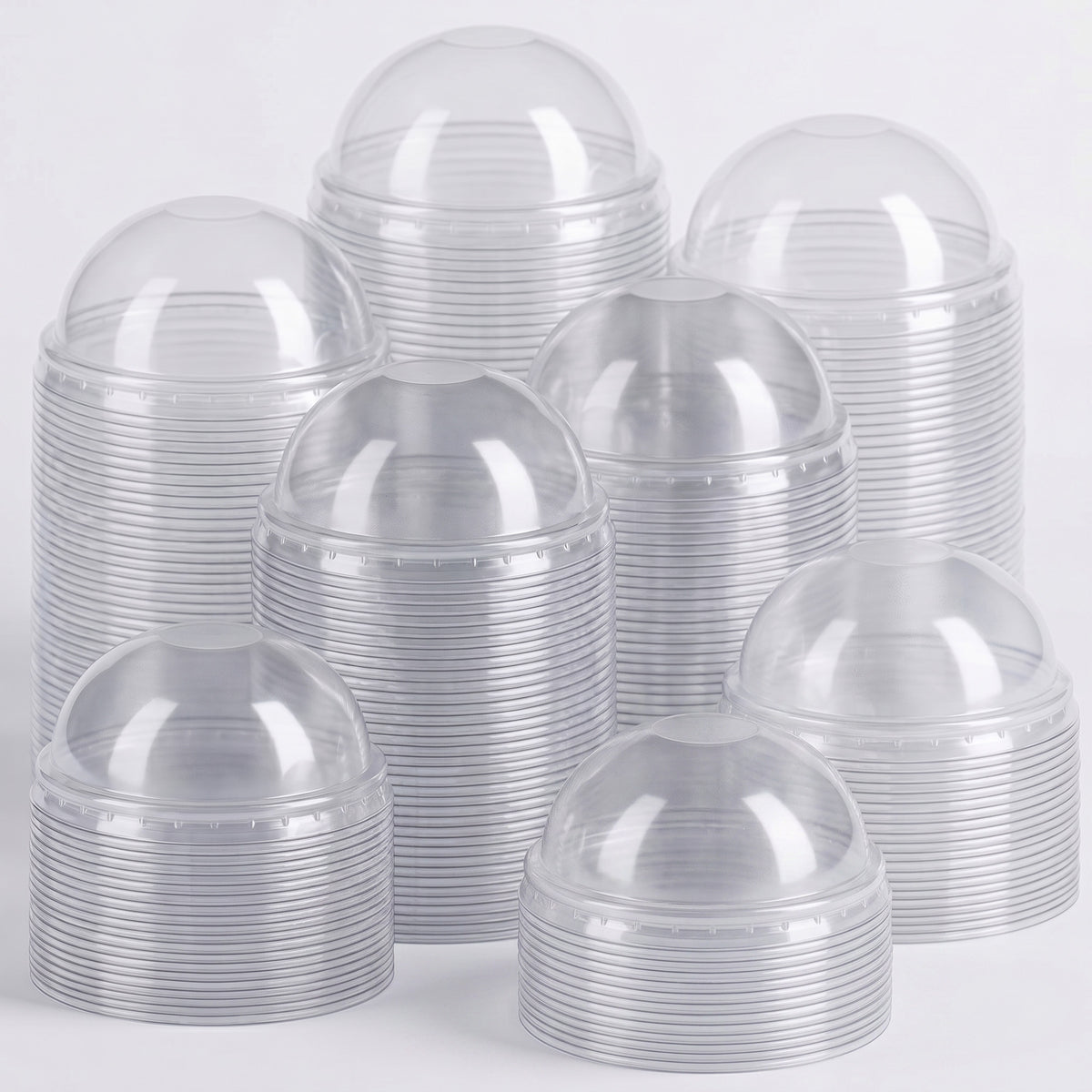 Stacks of clear plastic dome lids arranged in a pyramid, reflecting light softly. The scene is clean, organized, and industrial in tone.