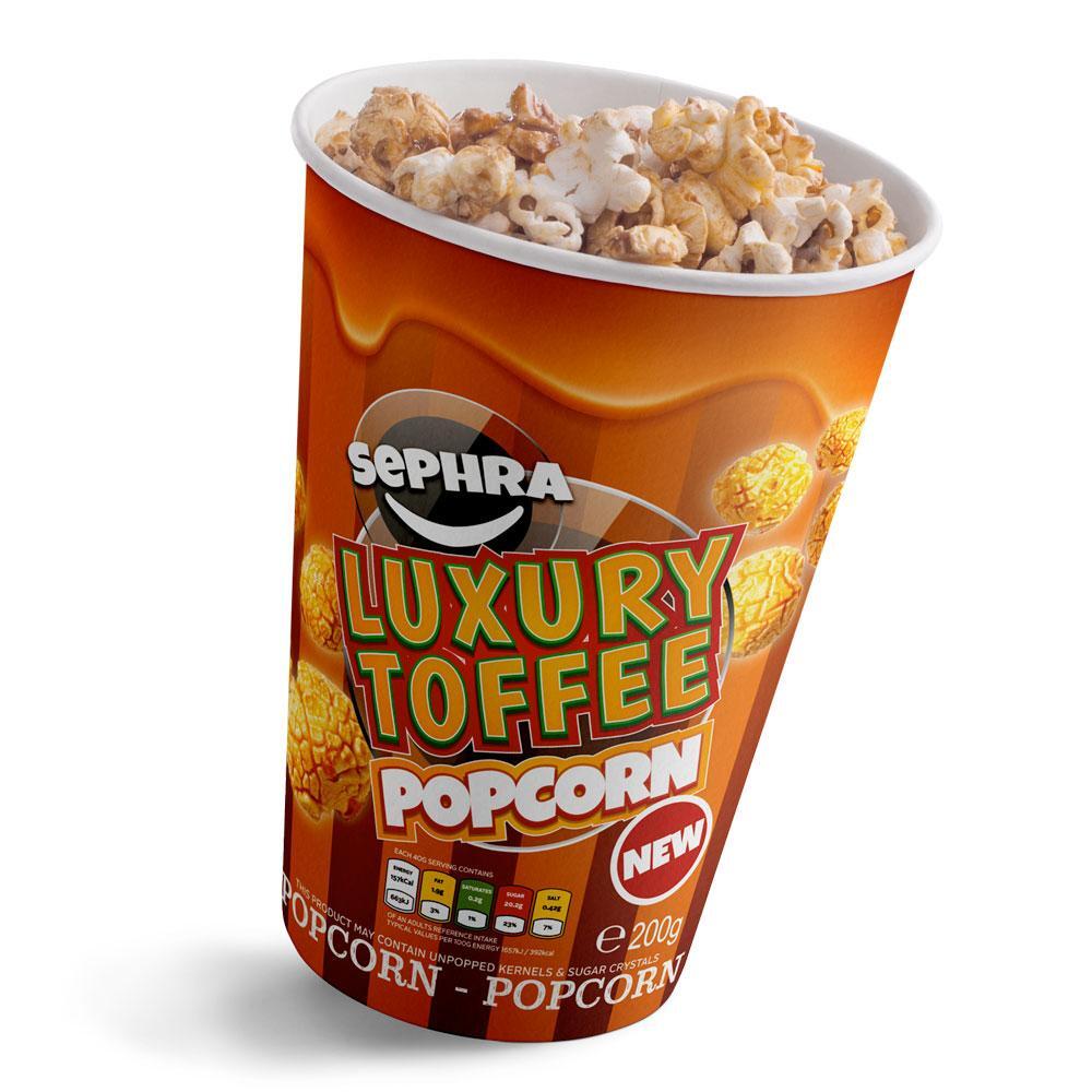 A cup of Sephra luxury toffee flavoured popcorn in an orange container labeled "new," filled with coated popcorn.