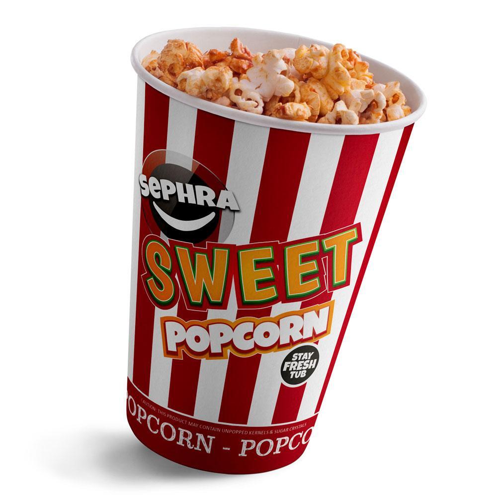 A striped red and white popcorn container filled with sweet popcorn.