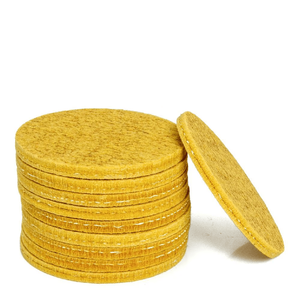 A stack of round felt pads in a mustard yellow color, with one mat leaning against the stack on a white background.
