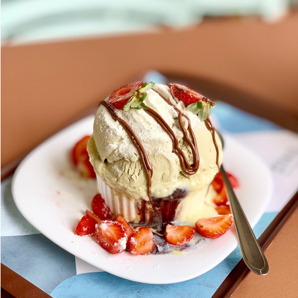 Delicious dessert topped with creamy ice cream, fresh strawberries, and rich chocolate hazelnut sauce drizzle – perfect for waffles, crepes, and sweet treat menus