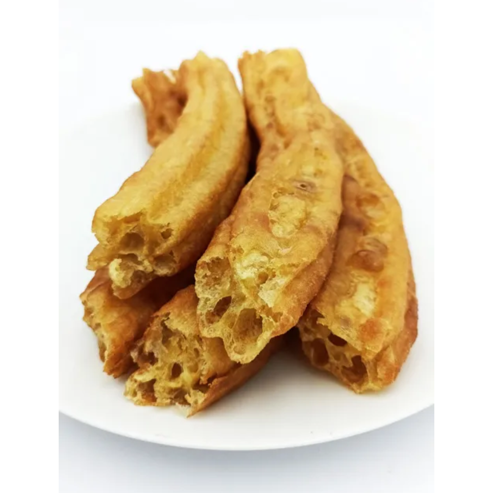 A plate filled with churros, showing the fried dough sticks with a crispy golden-brown exterior and a hollow interior.