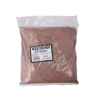 Clear plastic bag containing reddish-brown cola crystals with a "Westheads" label. The bag appears full and neatly sealed.