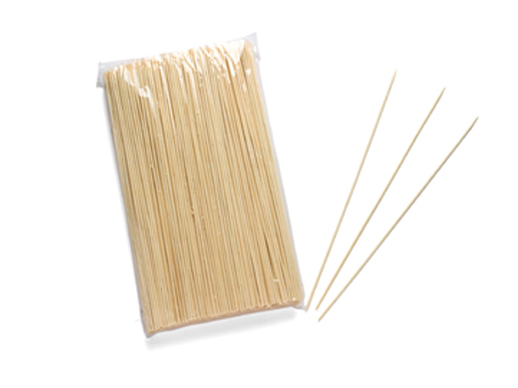 A clear plastic packet of pale bamboo skewers lies on a white background, with three loose skewers fanning outward for a clean, simple product image.