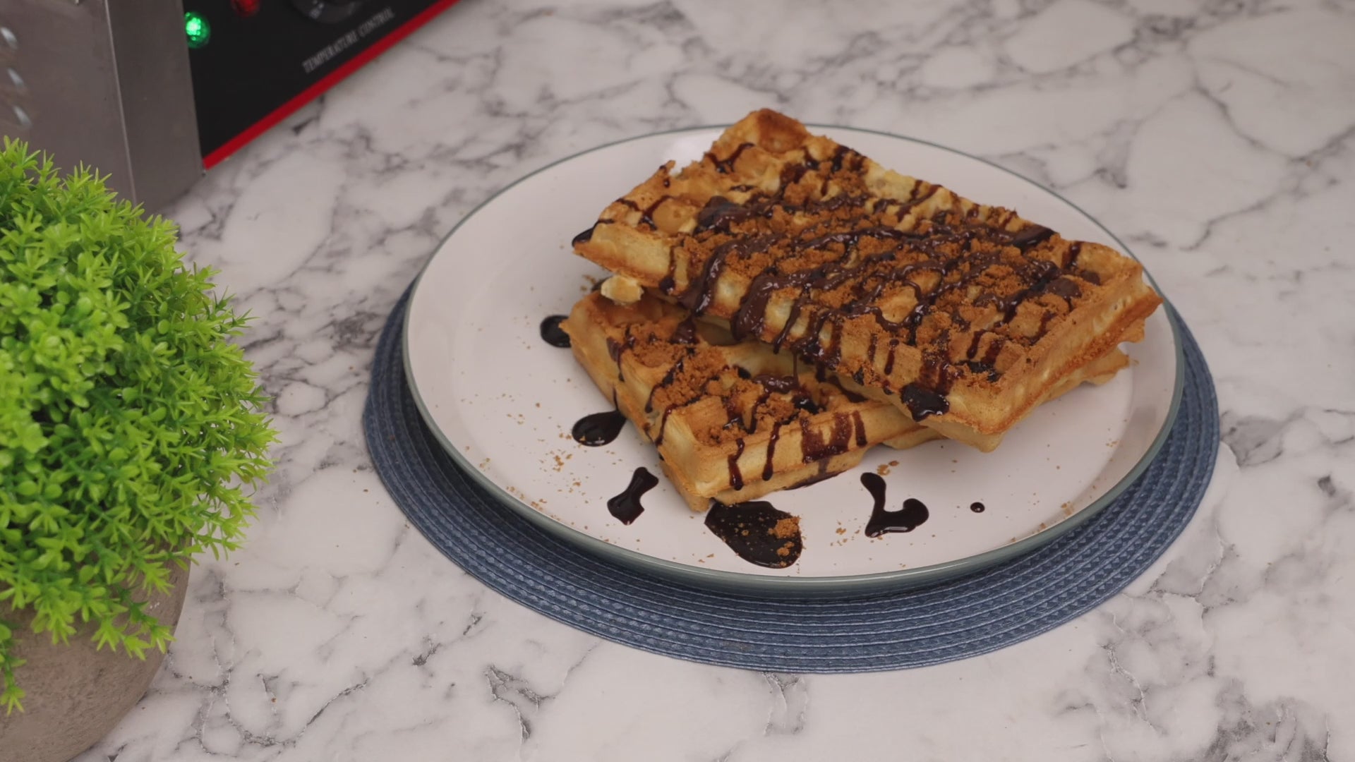 A close-up video showing waffle mix being poured smoothly onto a hot waffle iron. The batter spreads evenly as the lid is gently closed, ready to cook into golden waffles.