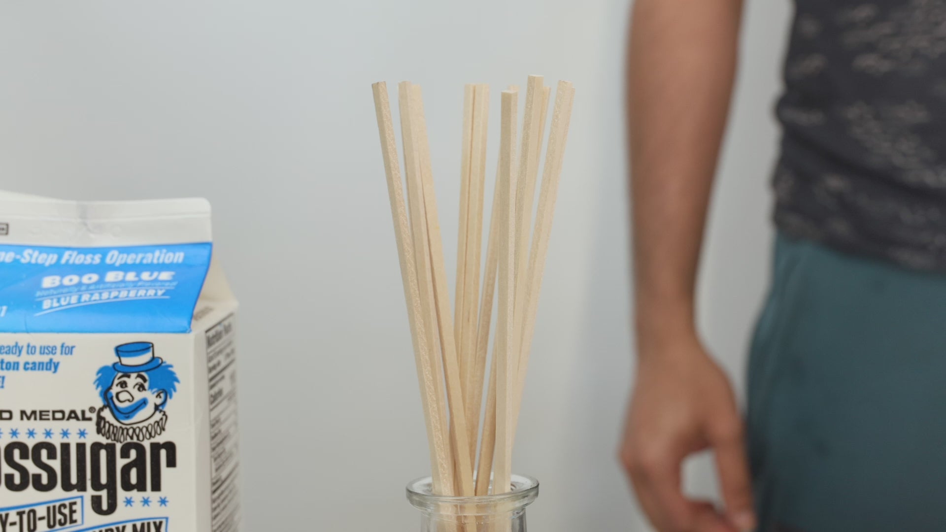 Golden brown snack sticks being poured into a clear container, showing their crisp texture and uniform shape.